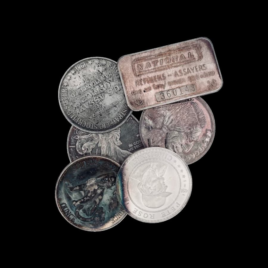 Assorted secondary-market 1 oz generic silver rounds and bars showing toning and wear